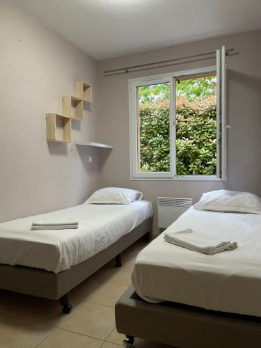 two beds in a room with a window at French country home III in Les Forges