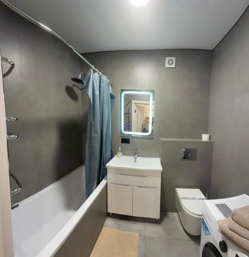 a bathroom with a sink and a toilet and a mirror at Dream 71 in Lutsk