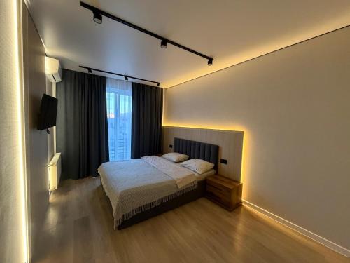 a bedroom with a bed and a large window at Dream 71 in Lutsk