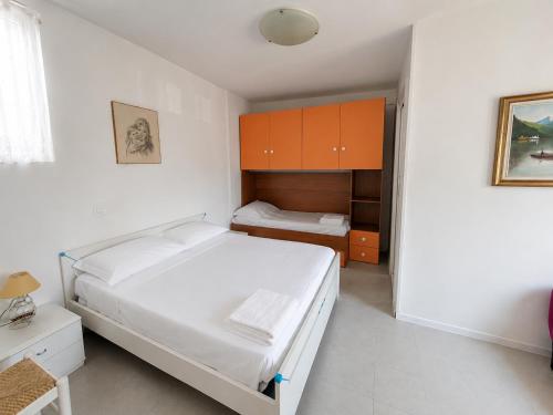 a bedroom with two beds and orange cabinets at Anthea - Timavo apartment 2 in Lignano Sabbiadoro