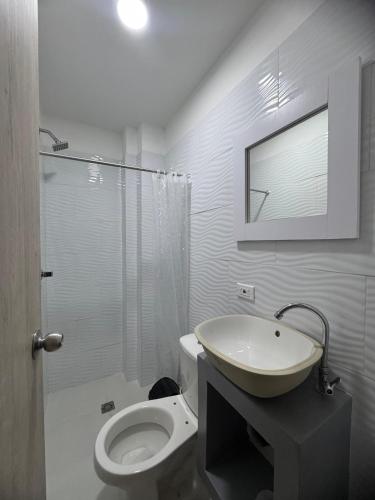 a white bathroom with a sink and a toilet at karolina Real Hotel Experience in Apartadó