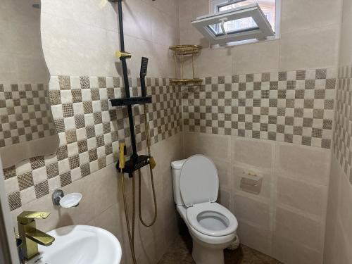 a bathroom with a white toilet and a sink at cosy house in Kobuleti