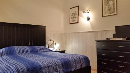 a bedroom with a bed and a dresser and a television at Casa Vacanze Nonno Giulio in Rome