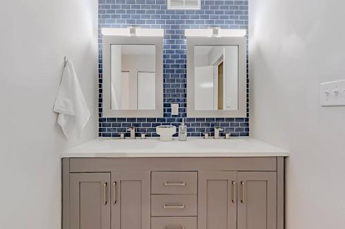 a bathroom with a sink and two mirrors at Modern 3BR With Big Kitchen & TV Rm in State College