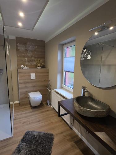 a bathroom with a sink and a toilet at WoDa's Hütte in Wickerode