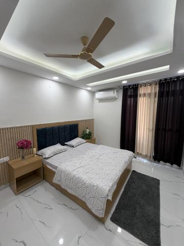 a bedroom with a bed and a ceiling fan at The Green Hush in Rājpur