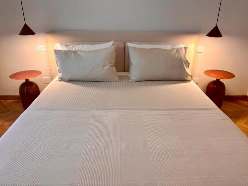 a large white bed with two pillows and two tables at Modern Apartment Empoli in Empoli