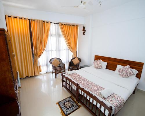a bedroom with a bed and a large window at Swapnatheeram Beach Resort in Kovalam