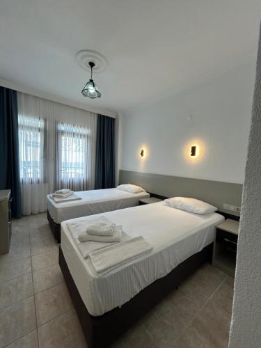 a hotel room with three beds in it at Ünlü Otel in Fethiye