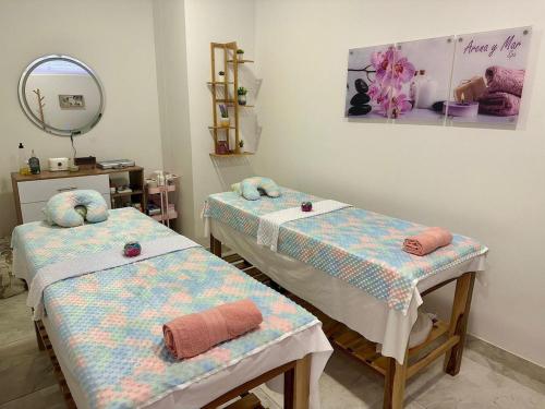 a room with two beds and a mirror at Corredor Suite - Eira Building - Santa Marta in Santa Marta