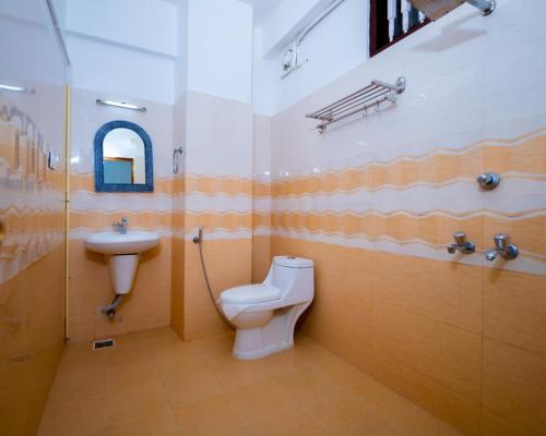 a bathroom with a toilet and a sink at Swapnatheeram Beach Resort in Kovalam