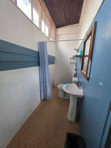a bathroom with a sink and a toilet and a window at Bamboo Khiri in Sathani Rot Fai