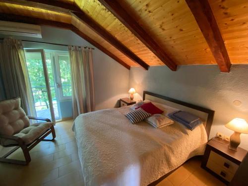 a bedroom with a large bed and a chair at Zeta River Retreat in Danilovgrad