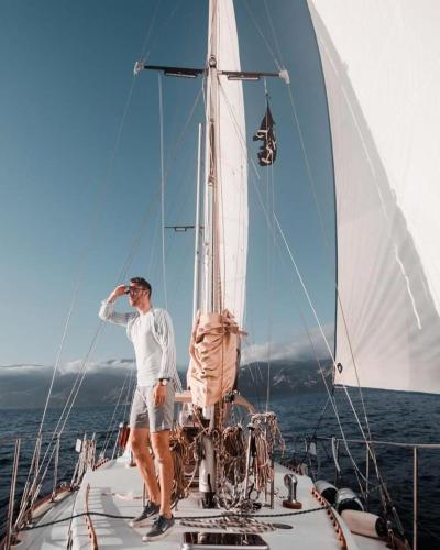 a man standing on the bow of a sailboat at Spica in Funchal