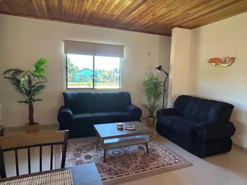 a living room with two blue couches and a table at Casa Alborada Bella Vista Itapúa in Bella Vista