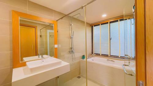 a bathroom with a sink and a tub and a mirror at MT Luxury Villas Phu Quoc in Phú Quốc