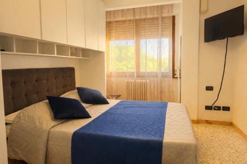 a bedroom with a bed with blue sheets and a television at Iris Viola in Bagno a Ripoli
