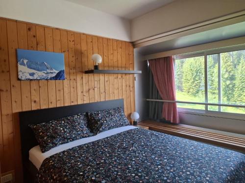 a bedroom with a bed and a large window at Casa Cris SoleAlto in Marilleva