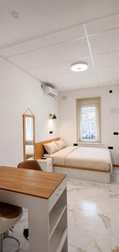 a bedroom with two beds and a desk and a table at Aloha Beach Apartament Con Baño privado in Alicante