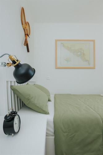 a room with a bed and a lamp and a clock at Captain`s Cottage in Kaštela