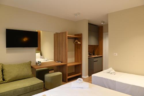 a room with two beds a couch and a kitchen at Prima Garden Residence in Durrës