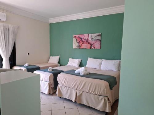 two beds in a room with blue walls at Pousada Zamberlan in Guarujá