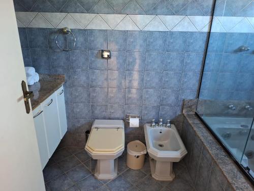 a bathroom with a toilet and a sink and a tub at Pousada Zamberlan in Guarujá
