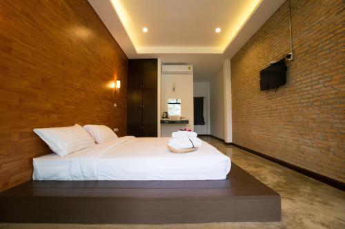 a bedroom with a bed and a brick wall at Pagoda Sight Residence in Nan