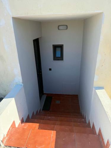 a stairway with a white wall and a door at PETROKALIVa in Galatás