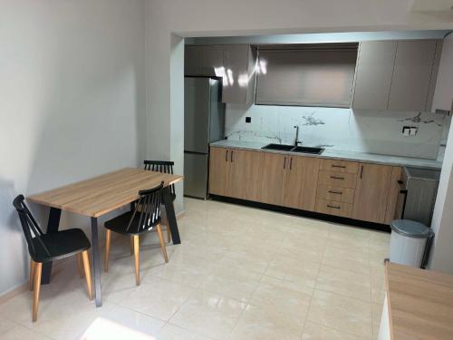 a kitchen with a wooden table and chairs and a sink at PETROKALIVa in Galatás
