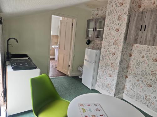 a kitchen with a white refrigerator and a green chair at St Peters Avenue in Cleethorpes