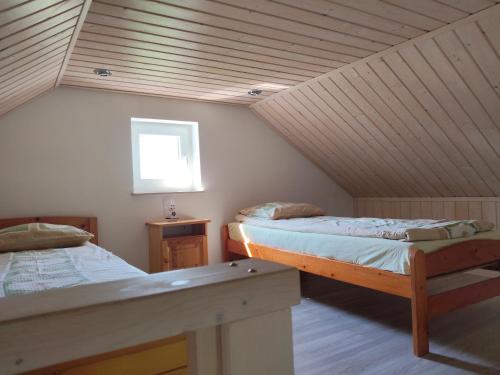 a attic room with two beds and a window at Domki Pod Kasztanem in Dąbki