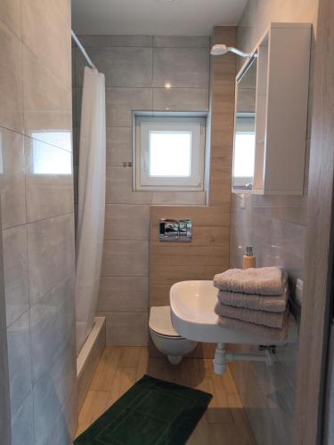a bathroom with a sink and a toilet and a window at Domki Pod Kasztanem in Dąbki
