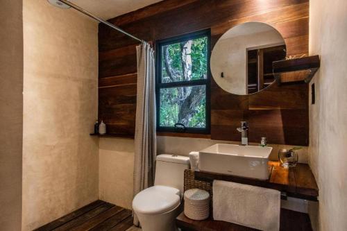a bathroom with a sink and a toilet and a window at Hotel Makaabá Eco-Boutique in Bacalar