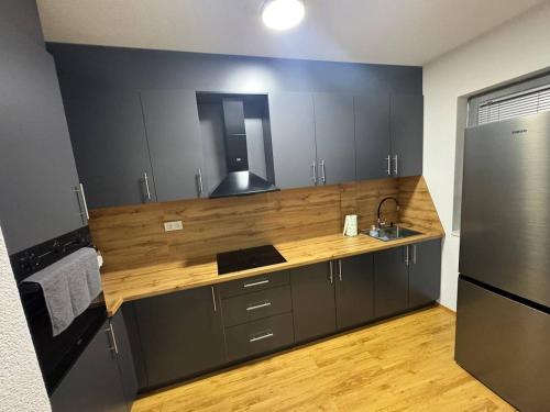 a kitchen with a counter with a sink and a refrigerator at DrimResidence in Struga