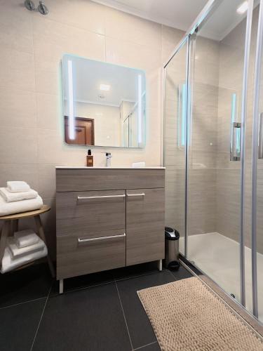 a bathroom with a sink and a mirror and a shower at Comfort Rooms Near Lisbon Airport - Carlotta Living in Lisbon