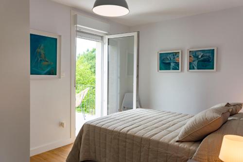 a bedroom with a bed and a sliding glass door at o fogar do cipres in Rivela