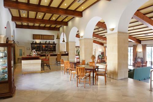 a restaurant with tables and chairs and a bar at Guadacorte Park in Los Barrios