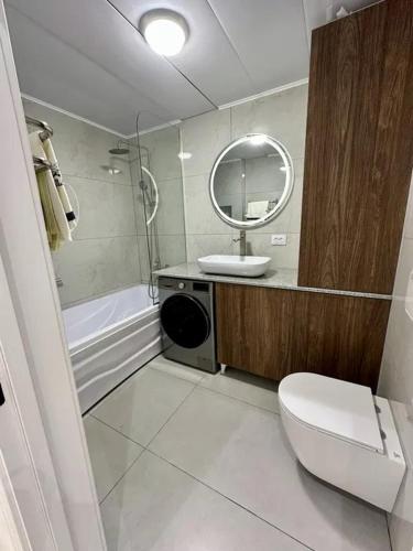 a bathroom with a toilet and a sink and a tub at Tamerlane Premium Apartment in Samarkand