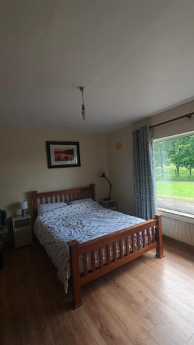 a bedroom with a wooden bed and a large window at Glencar in Sligo