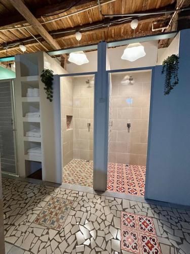 a bathroom with a walk in shower next to a wall at La Casa Rosada Hostel in Jericó