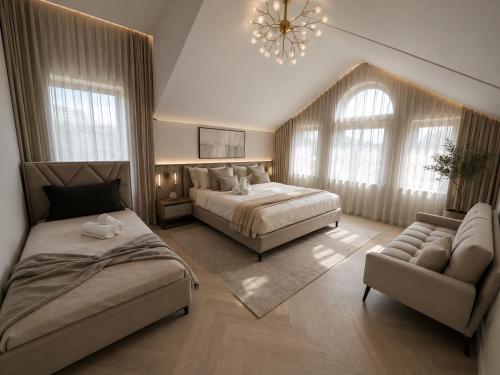 a bedroom with two beds and a couch and a chandelier at Villa Krasta in Elbasan