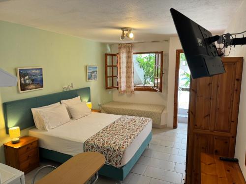 ein Schlafzimmer mit Bett und Flachbildfernseher in der Unterkunft Kipos Hotel in Limenas