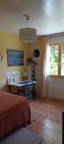 a bedroom with a desk and a table and a window at Chambre très calme in Montélimar