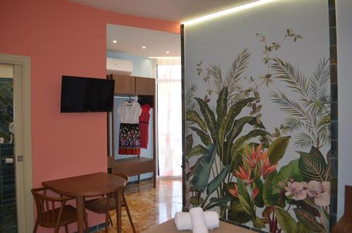 a living room with a wall with a painting of plants at Adua Rooms - Tropea Center in Tropea