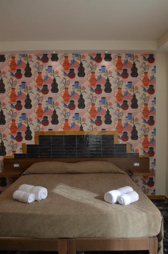a bedroom with a bed with two towels on it at Adua Rooms - Tropea Center in Tropea