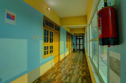 an empty hallway of a school with a fire extinguisher at Hotel O AP Hotel in Sitāpur