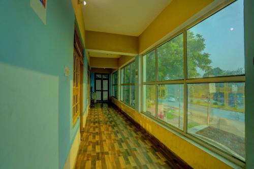 a hallway of a building with windows and a train at Hotel O AP Hotel in Sitāpur