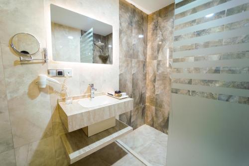a bathroom with a sink and a mirror at Erbil Quartz Hotel in Erbil