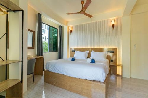 a bedroom with a large white bed and a desk at White Sand Maldives in Ukulhas